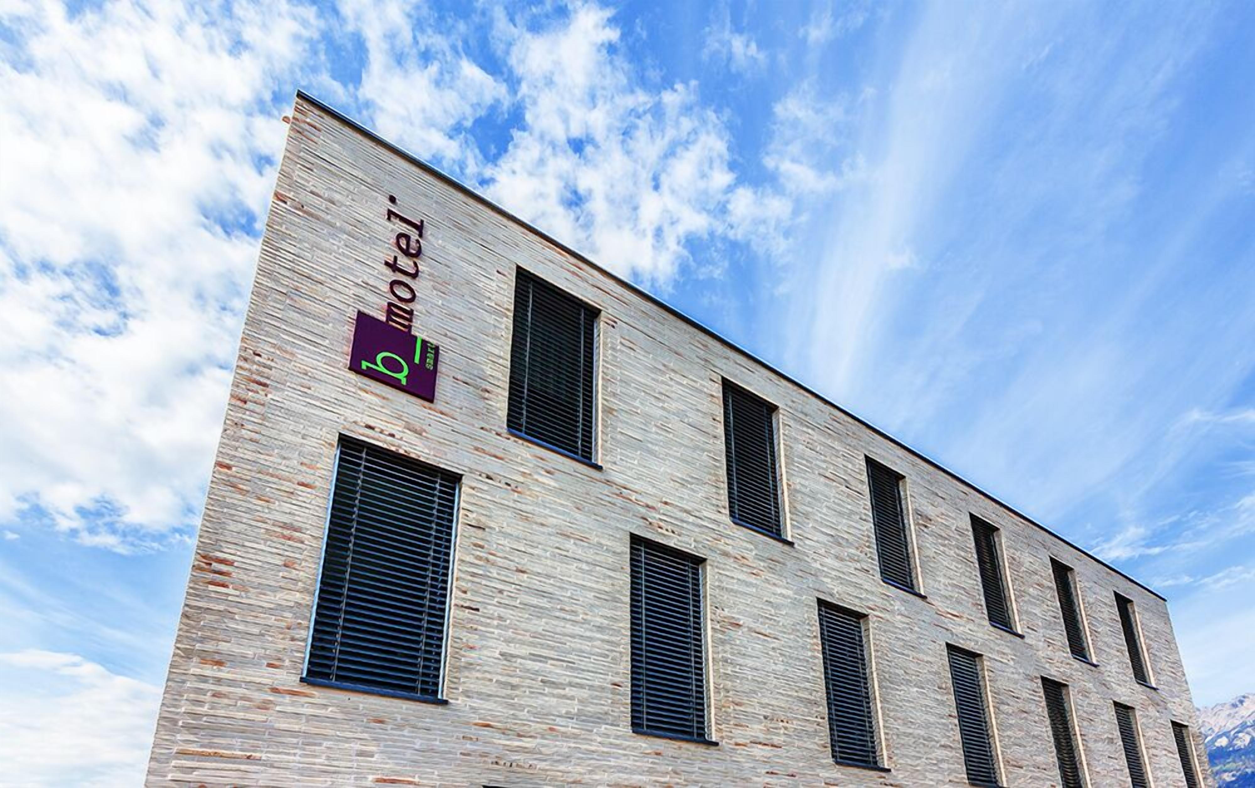 A modern brick building with multiple windows and a sign indicating it is a motel.