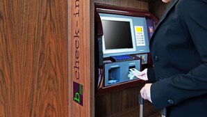 Una persona usando un quiosco de registro con un panel de madera y una pantalla digital.