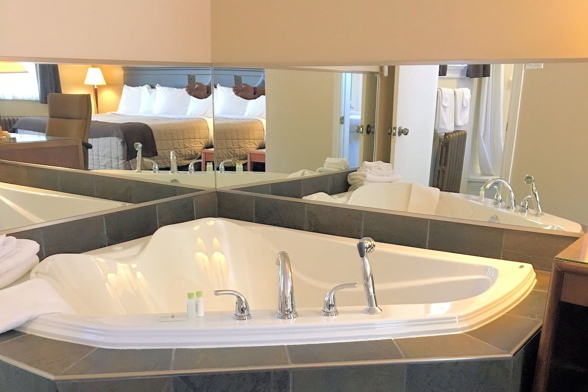 Un baño moderno con una bañera independiente, un espejo grande y una zona de ducha.