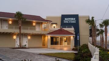 A hotel with a two-story structure, a red-tiled roof, and a prominent sign.