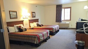 A hotel room with two beds, a desk, a chair, a window with curtains, and a ceiling-mounted air conditioning unit. - Park View Inn & Suites and Conference Center (West Bend)