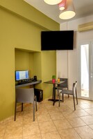Una habitación pequeña con escritorio, silla y televisor de pantalla plana montado en la pared.