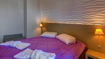 A hotel room with a large bed, two bedside lamps, and a textured wall design.