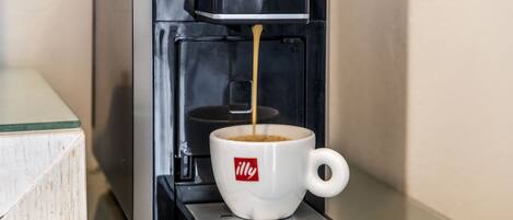 A coffee machine dispensing coffee into a cup with a logo.