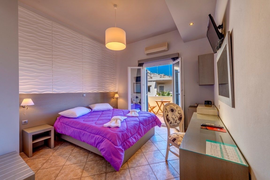 Une chambre à coucher comprenant un lit, une table de chevet, une lampe et un bureau avec une chaise.