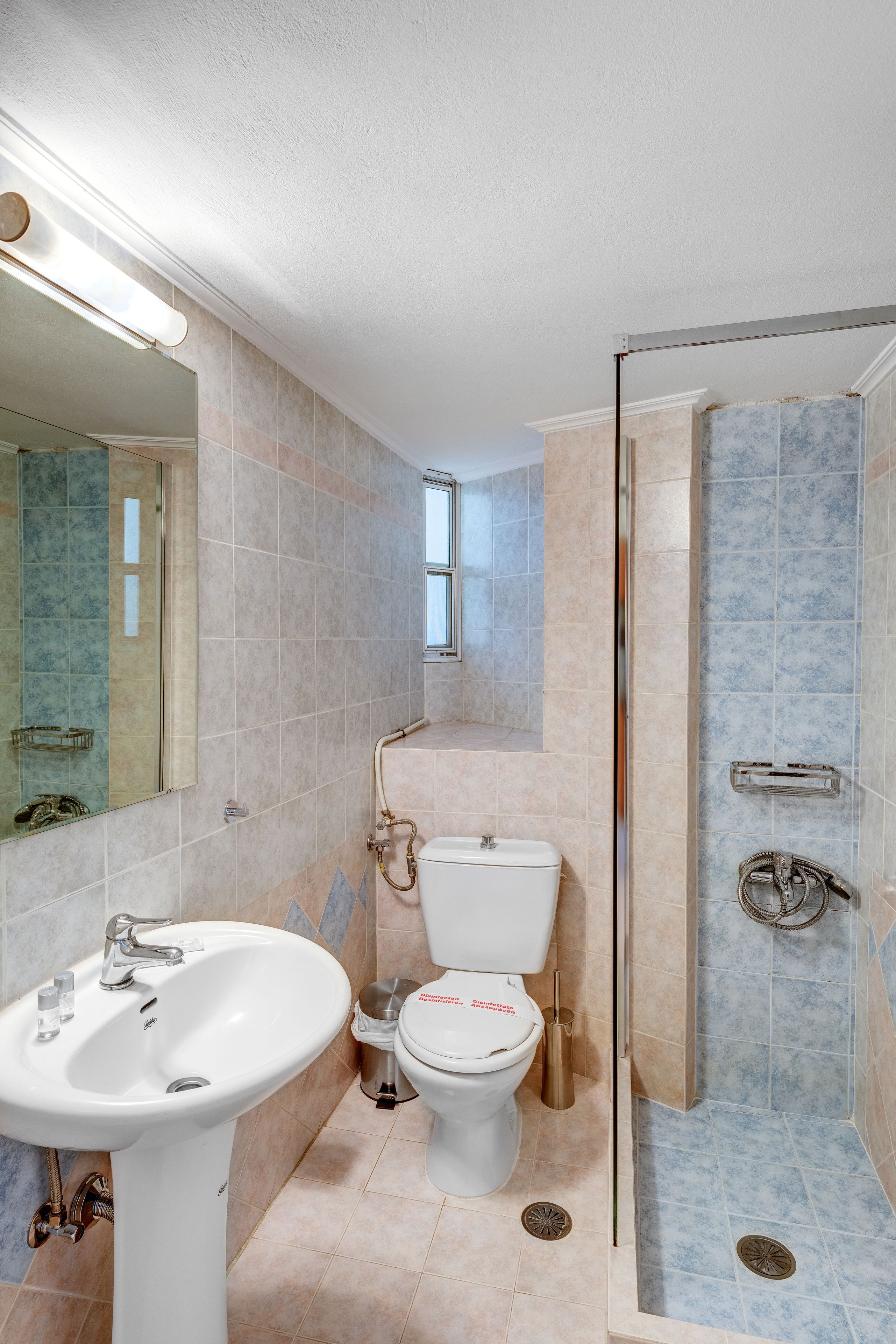 A bathroom with a sink, toilet, and glass-enclosed shower.