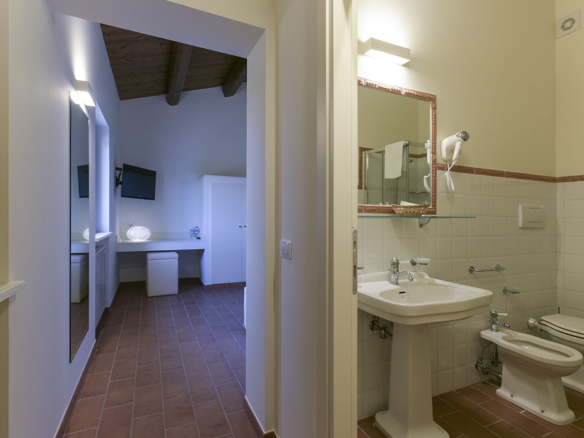 Un baño con lavamanos, inodoro y zona de ducha.