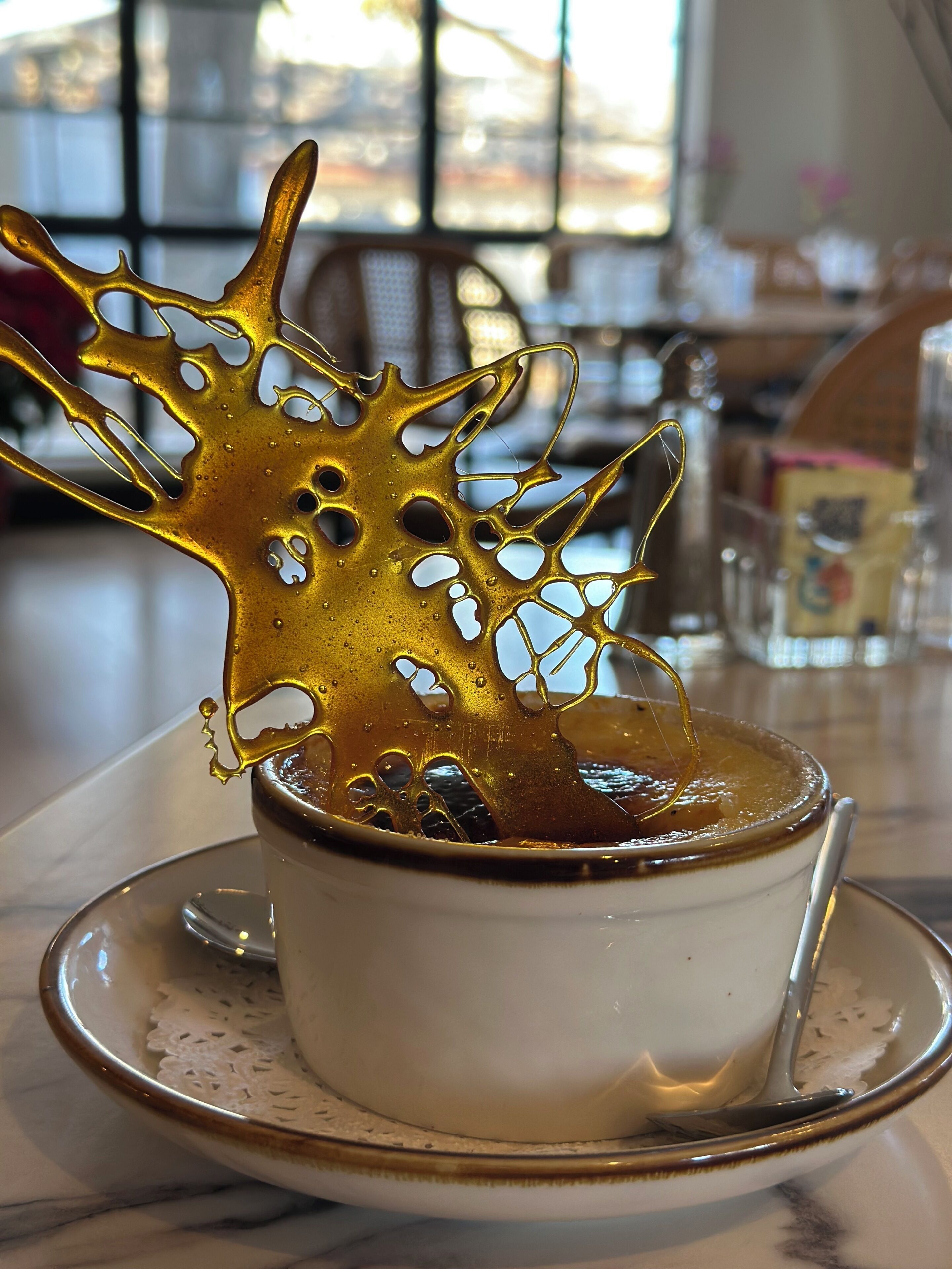 Una taza de café con un diseño dorado y detallado salpicando.