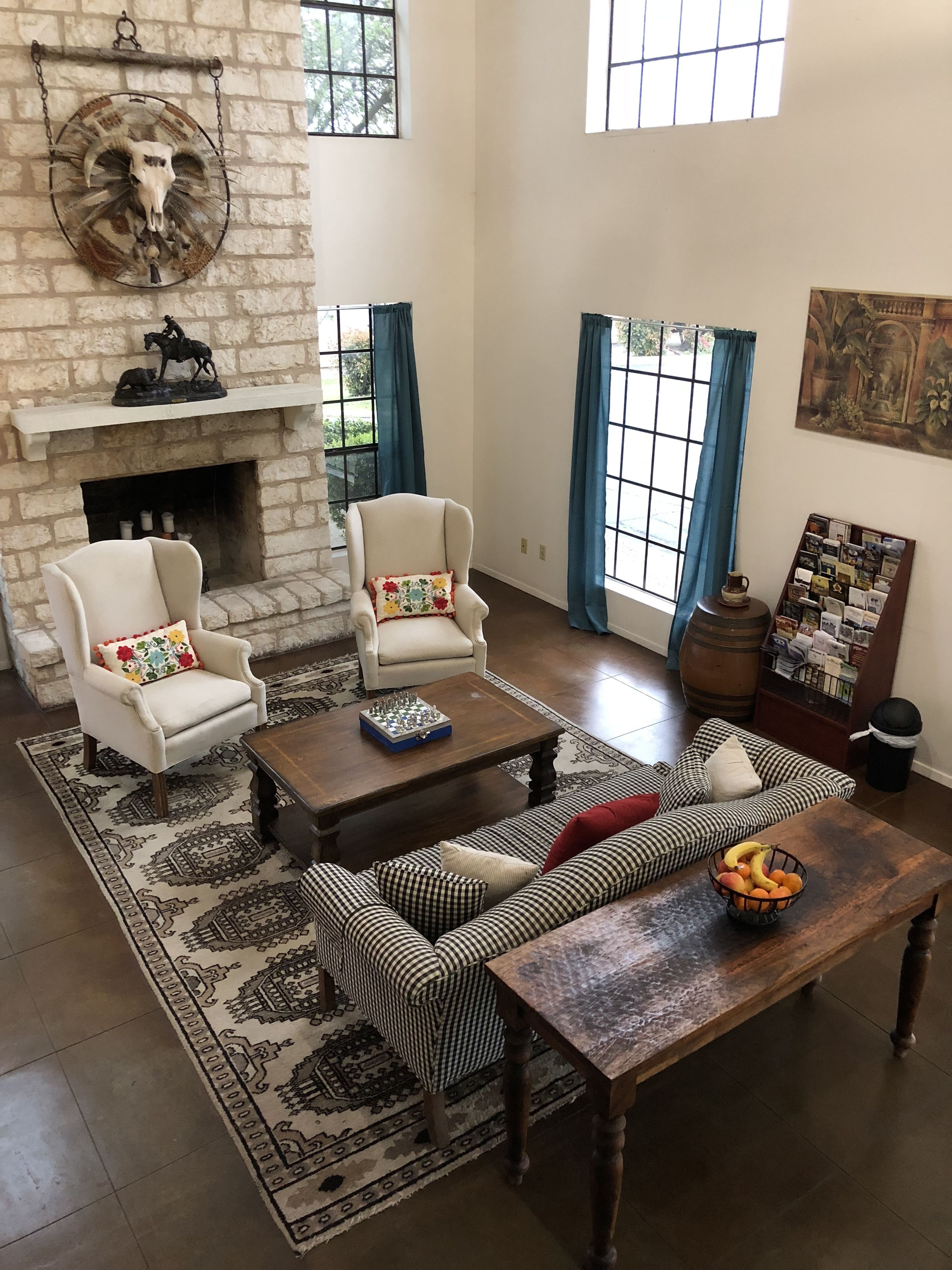 A living room with a fireplace, two armchairs, a sofa, a coffee table, and a rug.