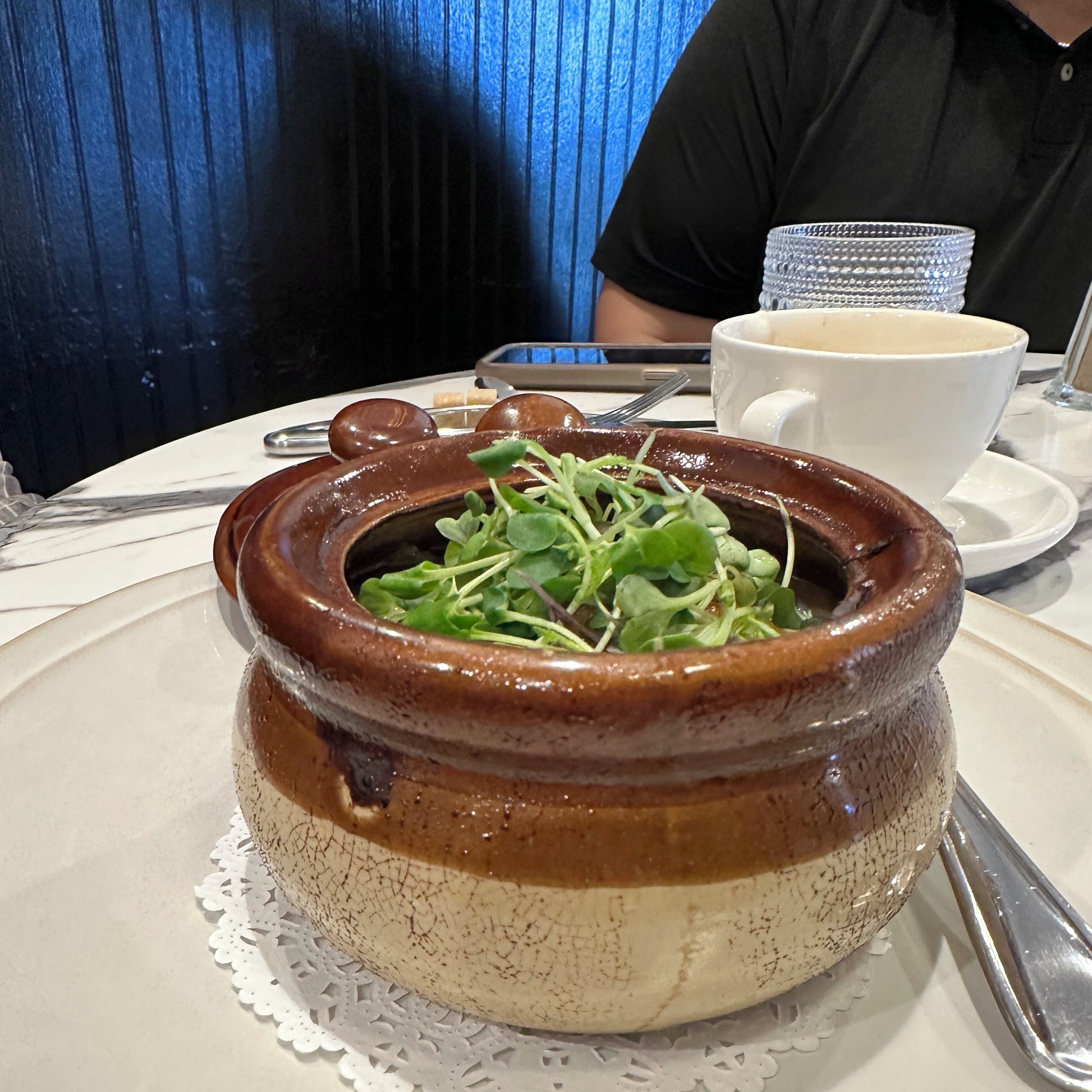 Un bol en céramique avec une plante dessus, posé sur une table.