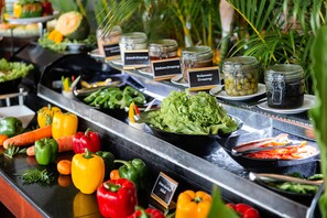 A buffet with various salads, vegetables, and dressings. - Ngwe Saung Yacht Club & Resort (Ngwe Saung)