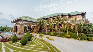 Um hotel com um pátio amplo, uma fonte e jardins exuberantes.