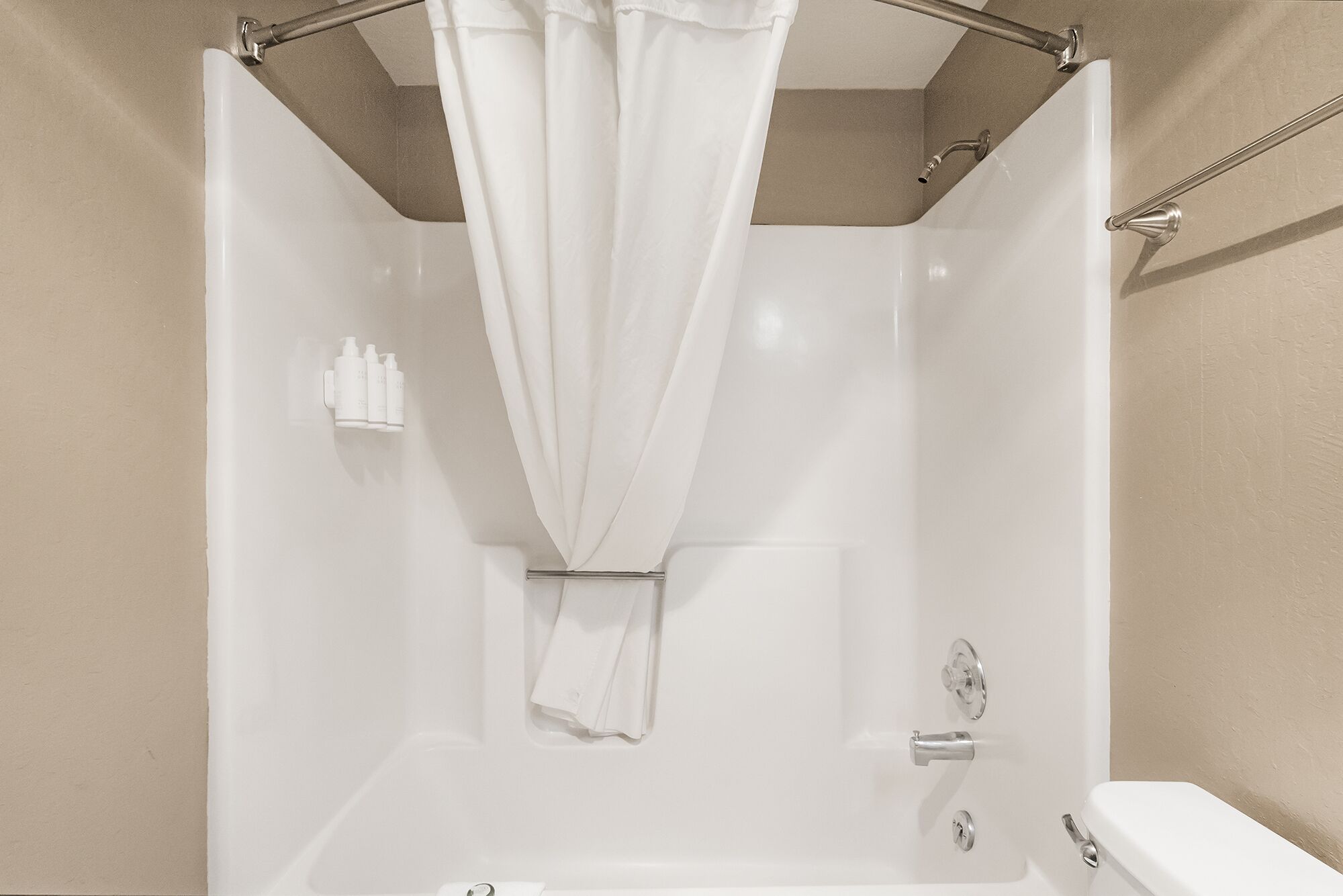Un baño moderno con bañera, cortina de ducha y retrete.