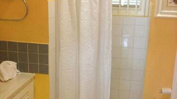 A bathroom with a shower curtain, a towel rack, and a toilet.