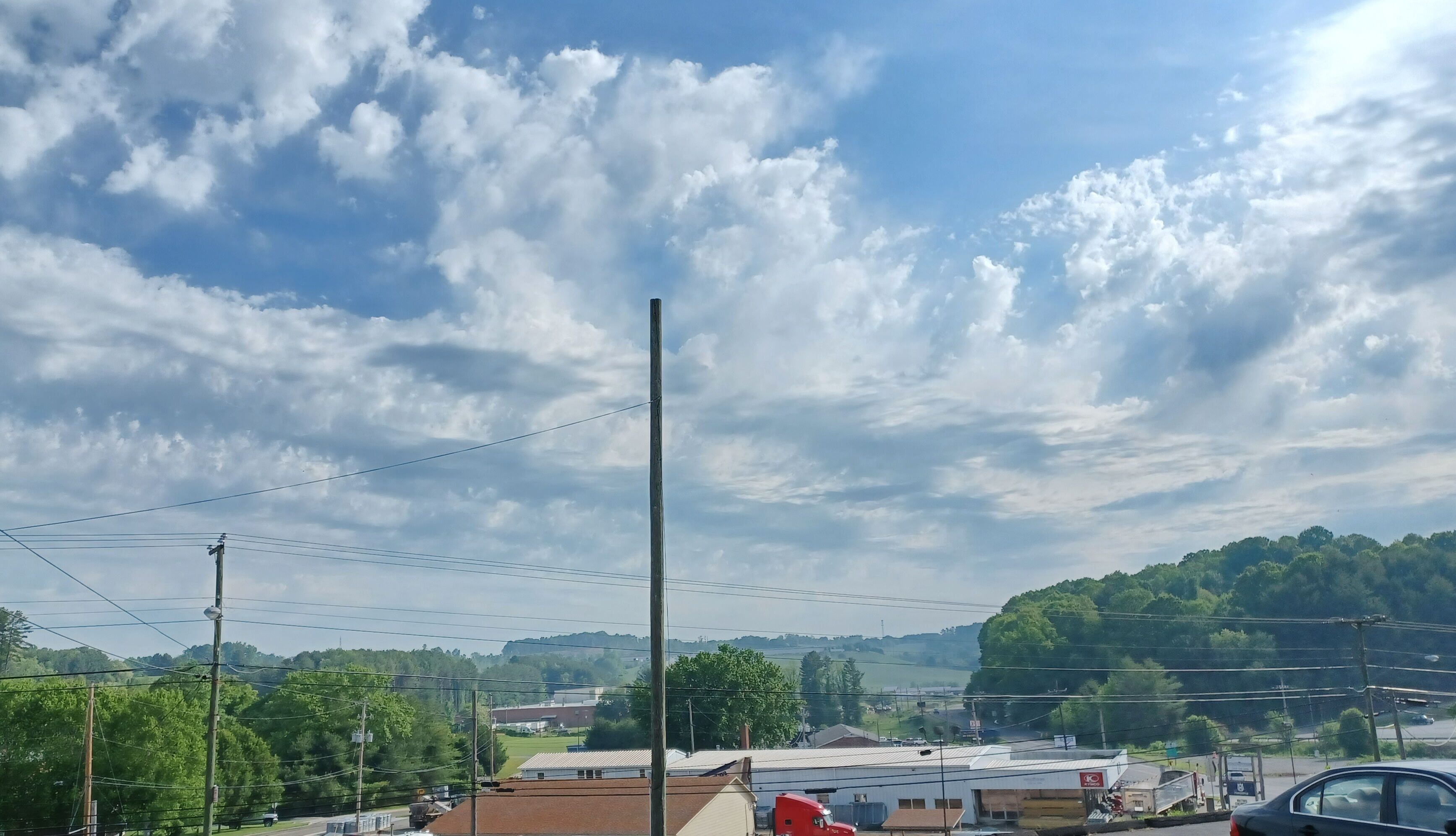 Vista de un pueblo con edificios, líneas eléctricas y un cielo nublado.