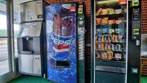 Ein Getränkeautomat mit Pepsi-Logo, ein Wasserspender und ein Snackautomat.