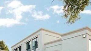 Un edificio moderno con tejado plano, ventanas amplias y fachada simétrica.
