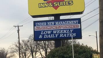 A sign for Diamond Inn & Suites advertising new management and renovated rooms with low weekly and daily rates.