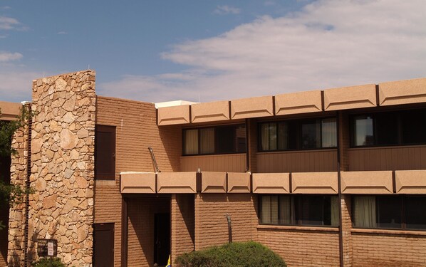 A building with a stone facade, multiple windows, and a flat roof.