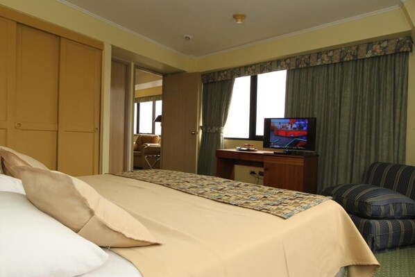 A hotel room with a bed, a television, a desk, and a chair. - LRH Viña del Mar and Convention Center (Vina del Mar)