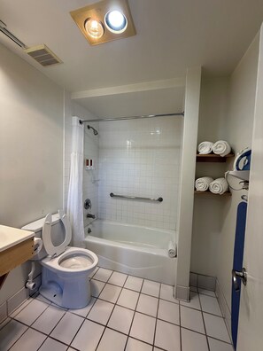 Un baño con inodoro, bañera, ducha y un perchero para toallas.