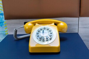 Um telefone de disco amarelo sobre uma superfície azul.