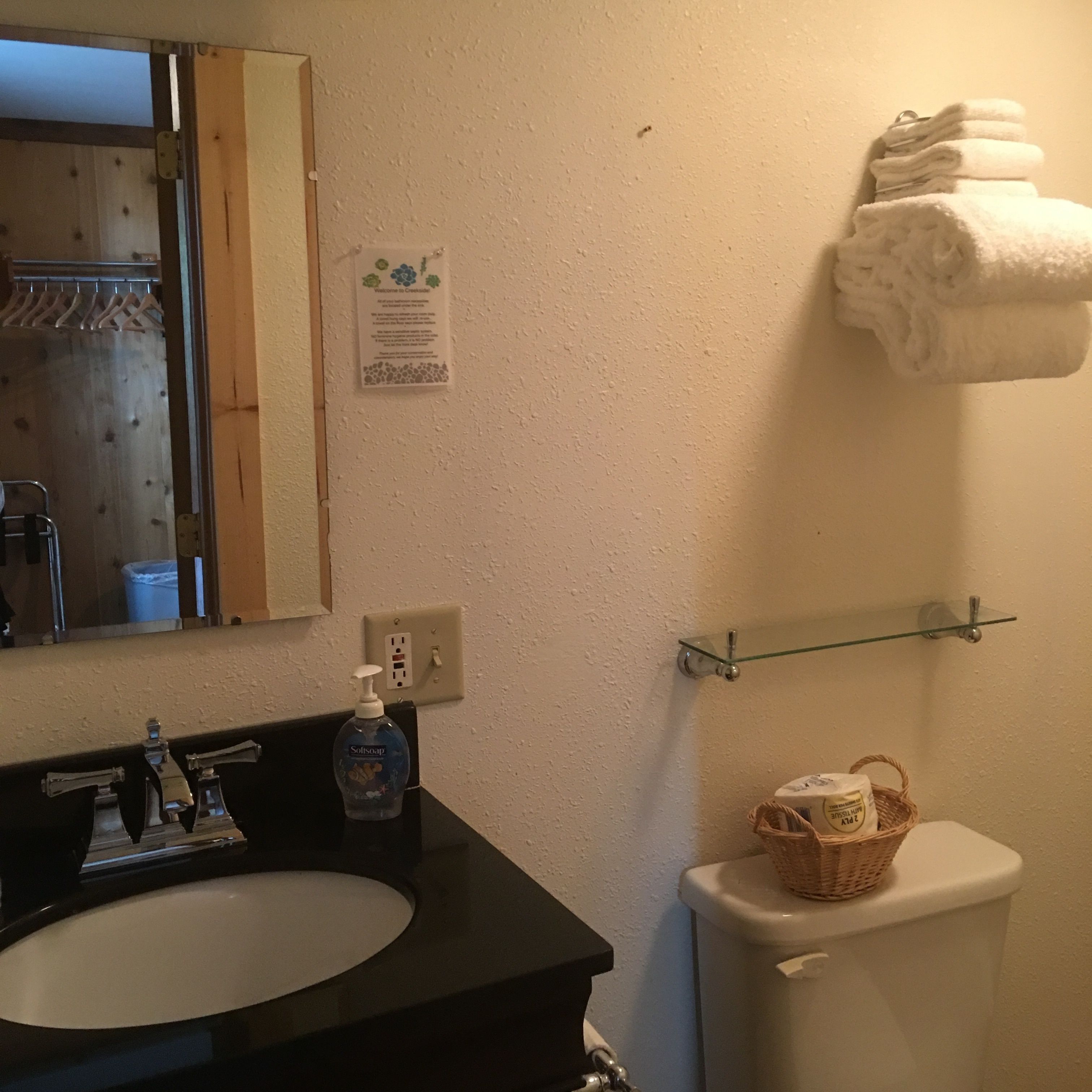 A bathroom with a sink, mirror, and a towel rack.