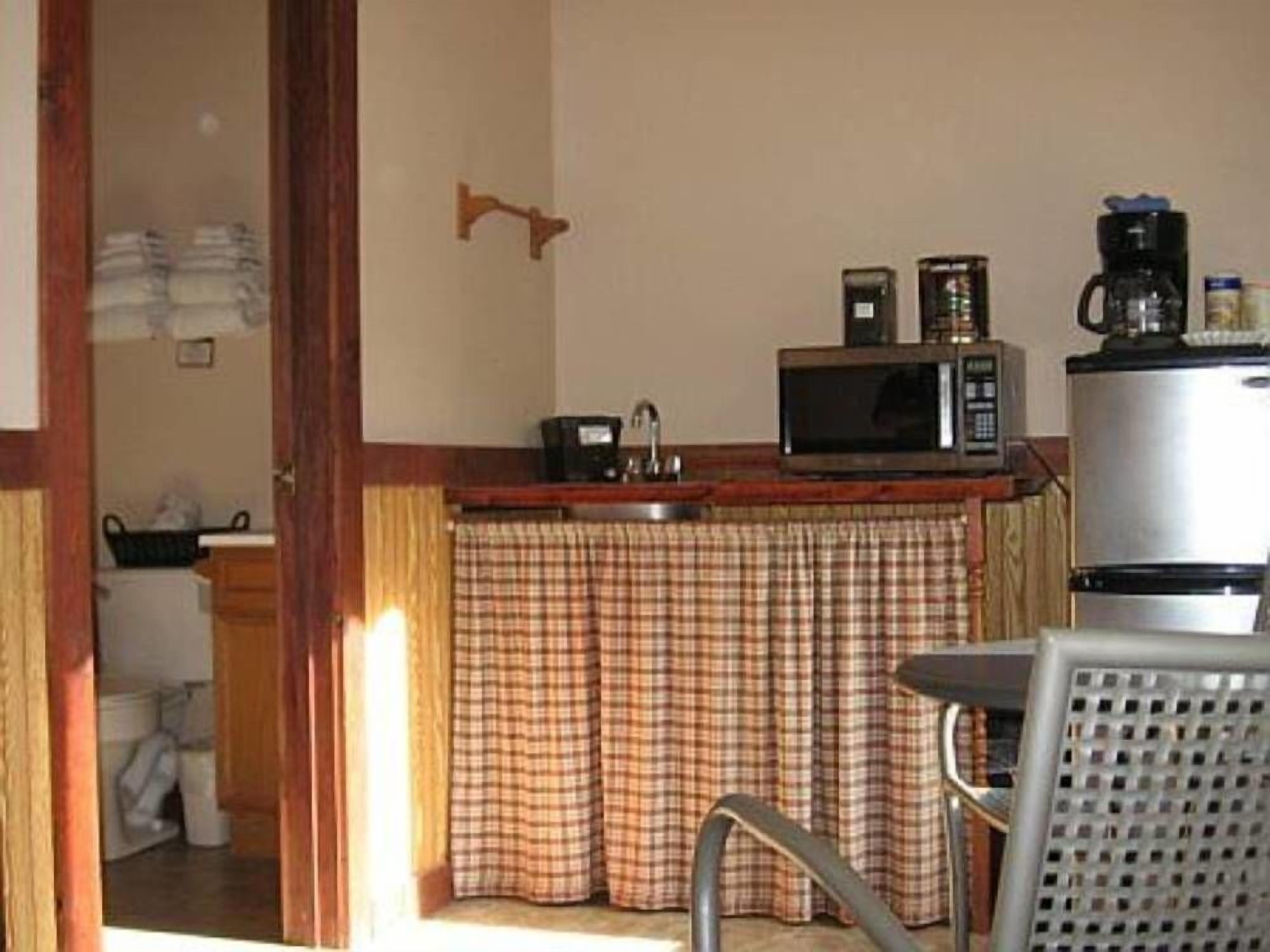 A compact kitchen with a microwave, coffee maker, and refrigerator.