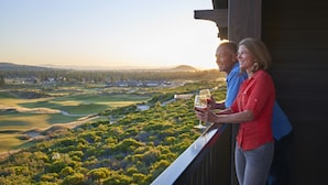 A couple standing on a balcony overlooking a golf course with a clear view of the landscape. - Tetherow Resort (Bend)