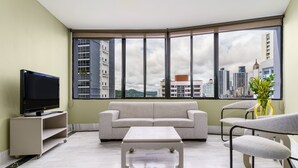 Una sala de estar moderna con un sofá, una mesa de centro y un televisor sobre un mueble.