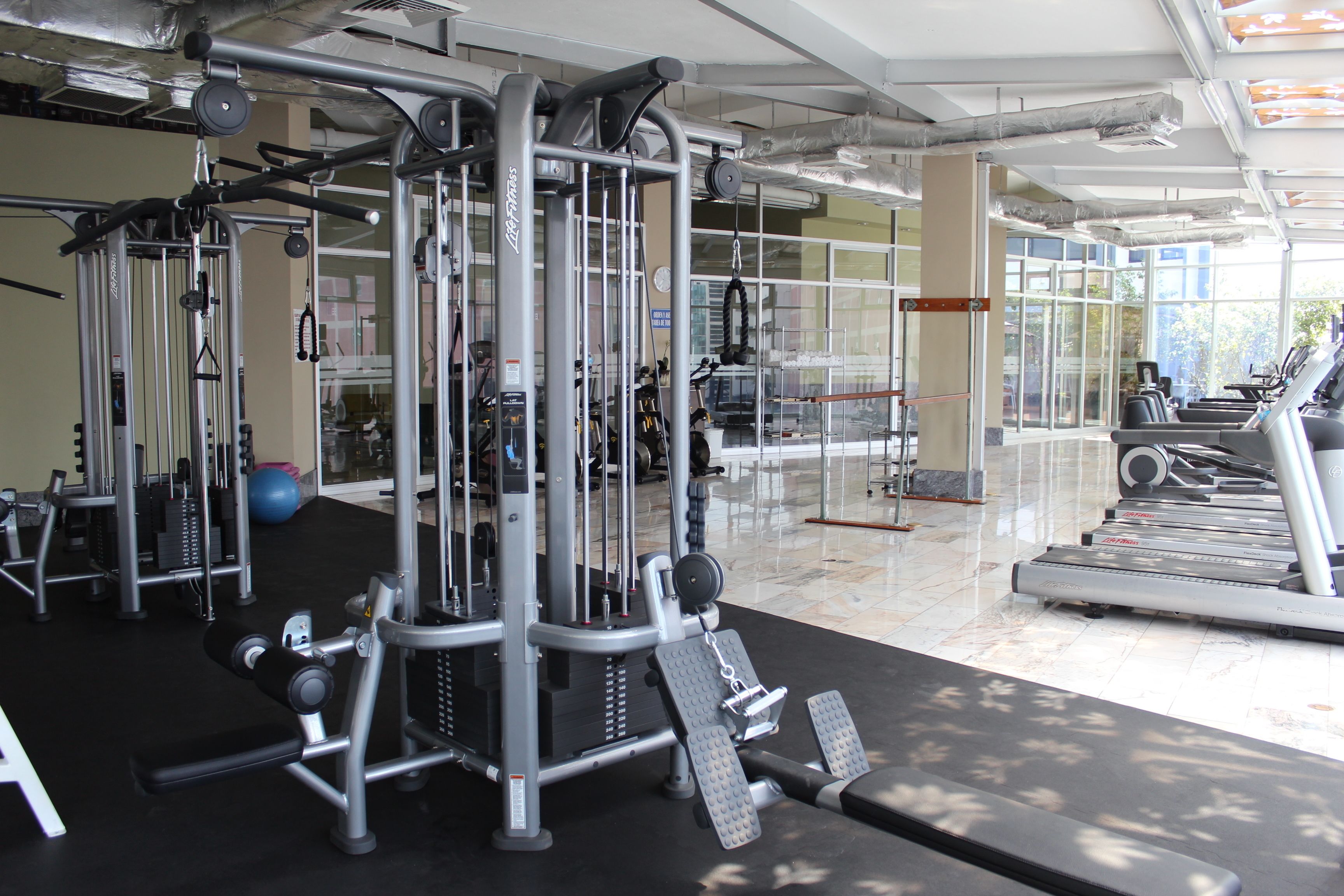A gym with various exercise equipment, including weight machines and treadmills.