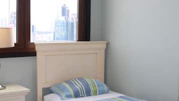 Une chambre à coucher avec un lit, une table de chevet et une fenêtre donnant sur la ville.