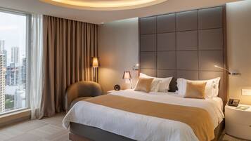 A modern hotel room with a large bed, a city view, and a well-lit ambiance.