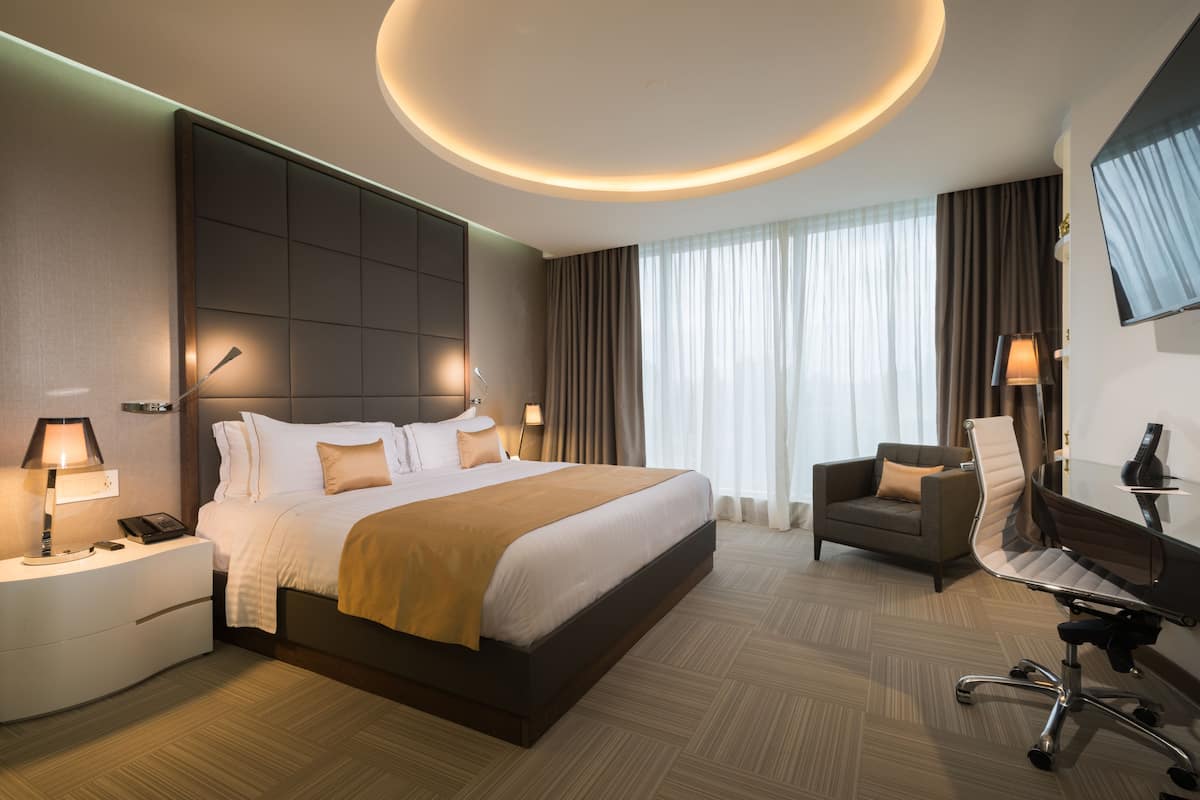 Een moderne hotelkamer met een groot bed, een bureau, een stoel en een televisie.