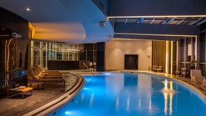 Una piscina interior con sillones de descanso y un diseño de interiores moderno.
