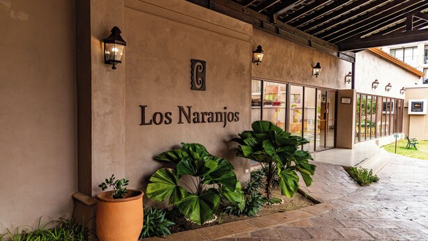 A building facade with the sign "Los Naranjos" and large potted plants. - Hotel Cubitá Boutique Resort & Spa (La Arena)