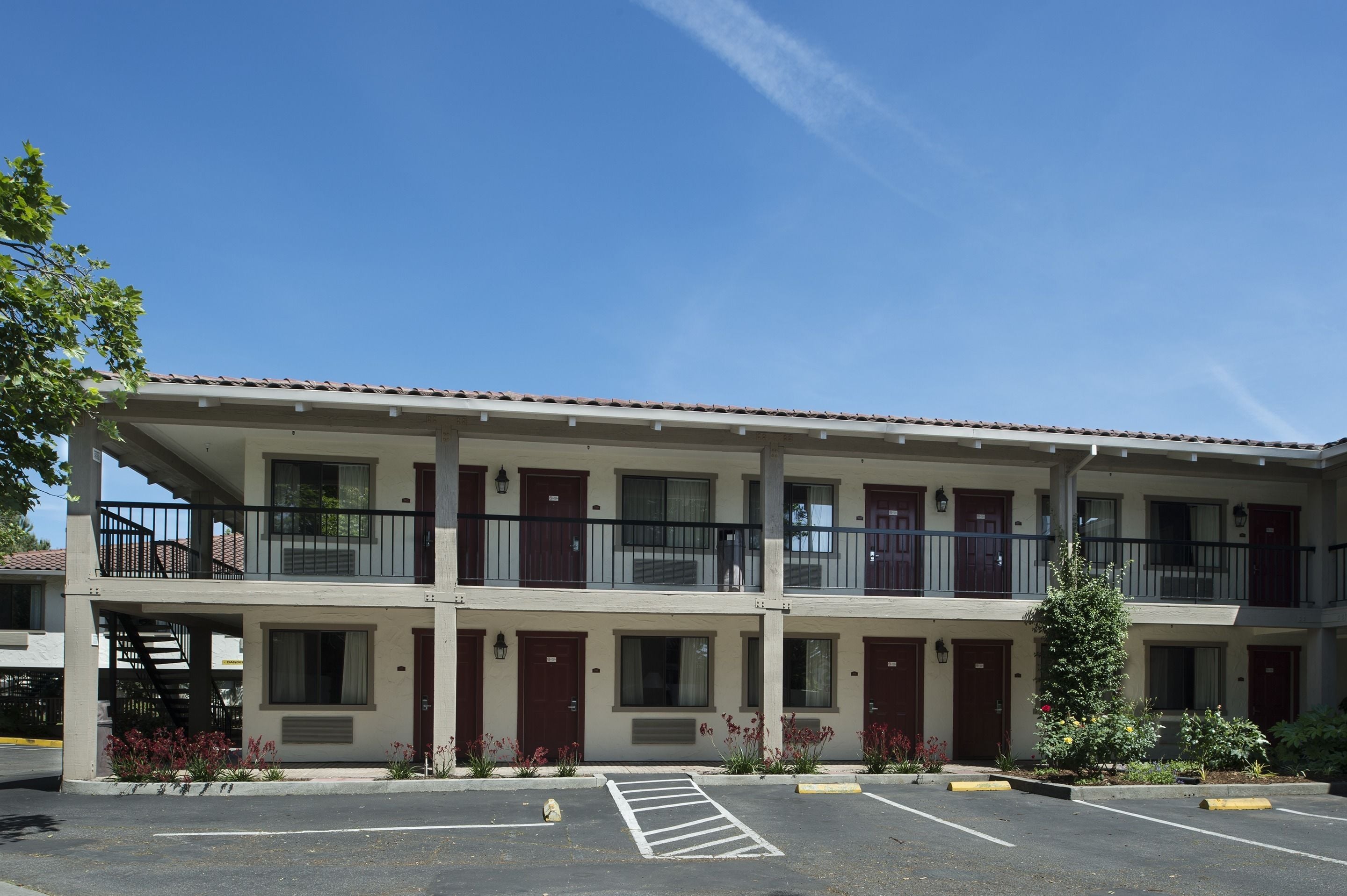 A two-story motel with a parking lot in front.