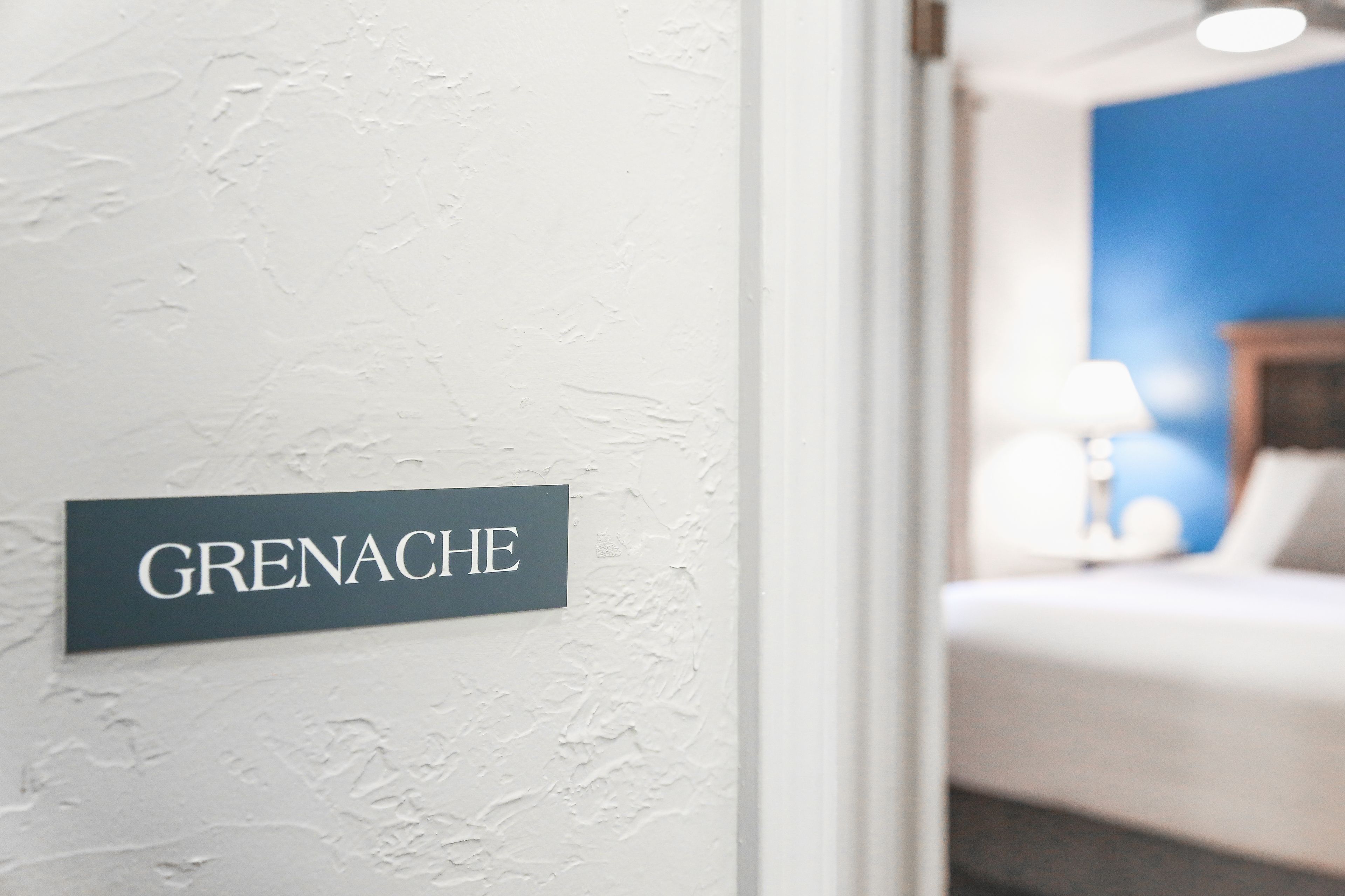 Une pancarte sur un mur à texture indiquant : « GRENACHE ».