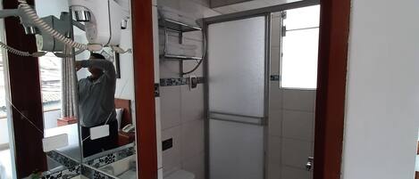 Een badkamer met toilet, douche en wastafel.