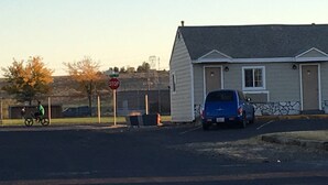 A small building with a garage, a stop sign, and a bicycle in the foreground. - Umatilla Inn and Suites (Umatilla)