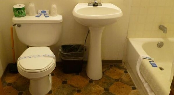 A bathroom with a toilet, sink, and bathtub.