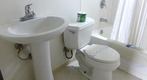 A bathroom with a white sink, toilet, and bathtub.
