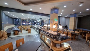 Un restaurant moderne doté de plusieurs espaces de restauration, d’un buffet et de différents types d’éclairages.
