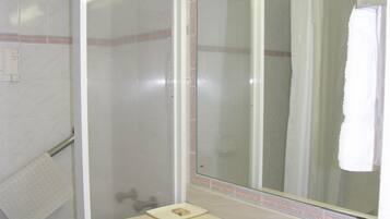 A bathroom with a shower, a sink, and a mirror.