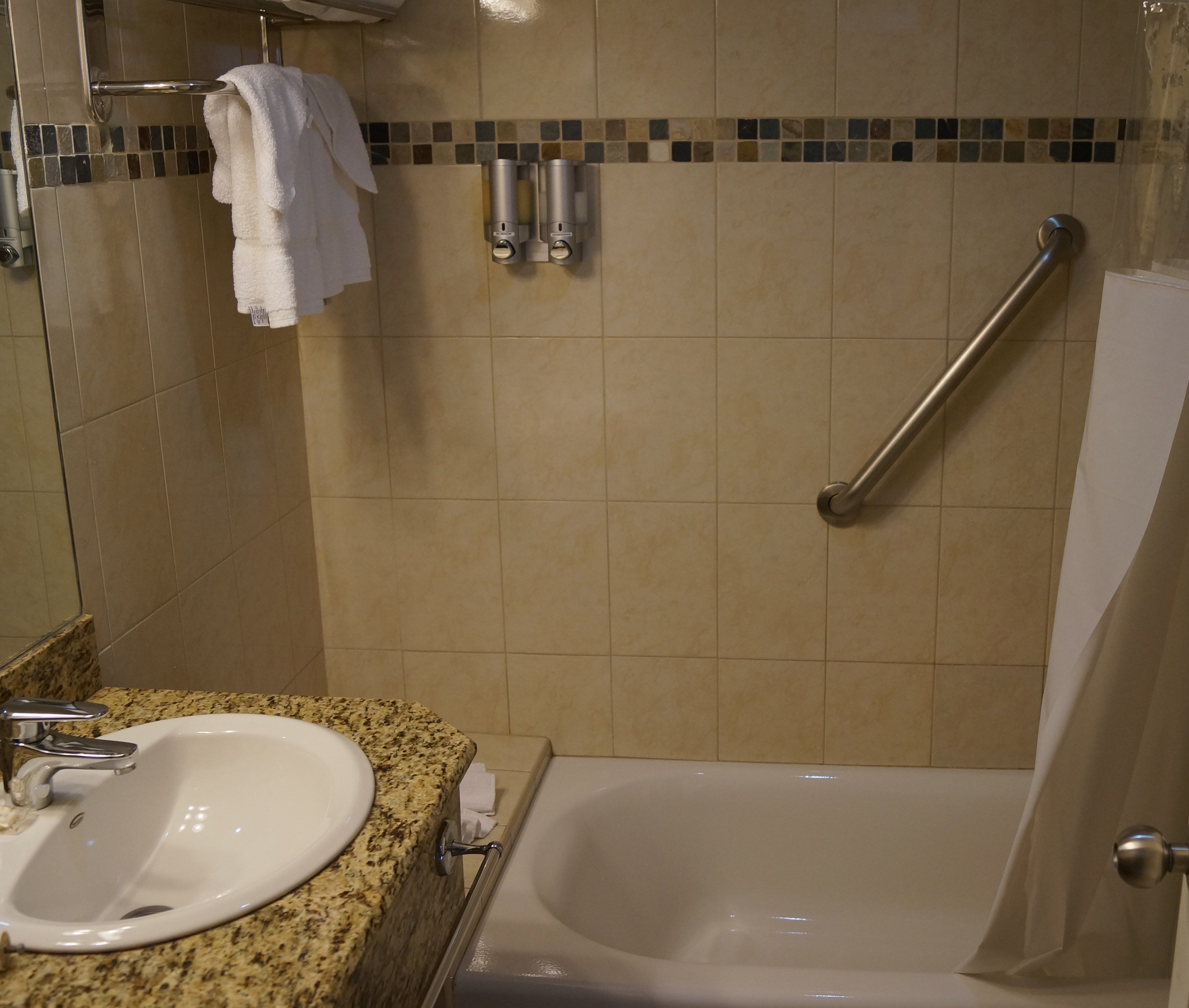 Une salle de bain avec un lavabo, un miroir et une baignoire.