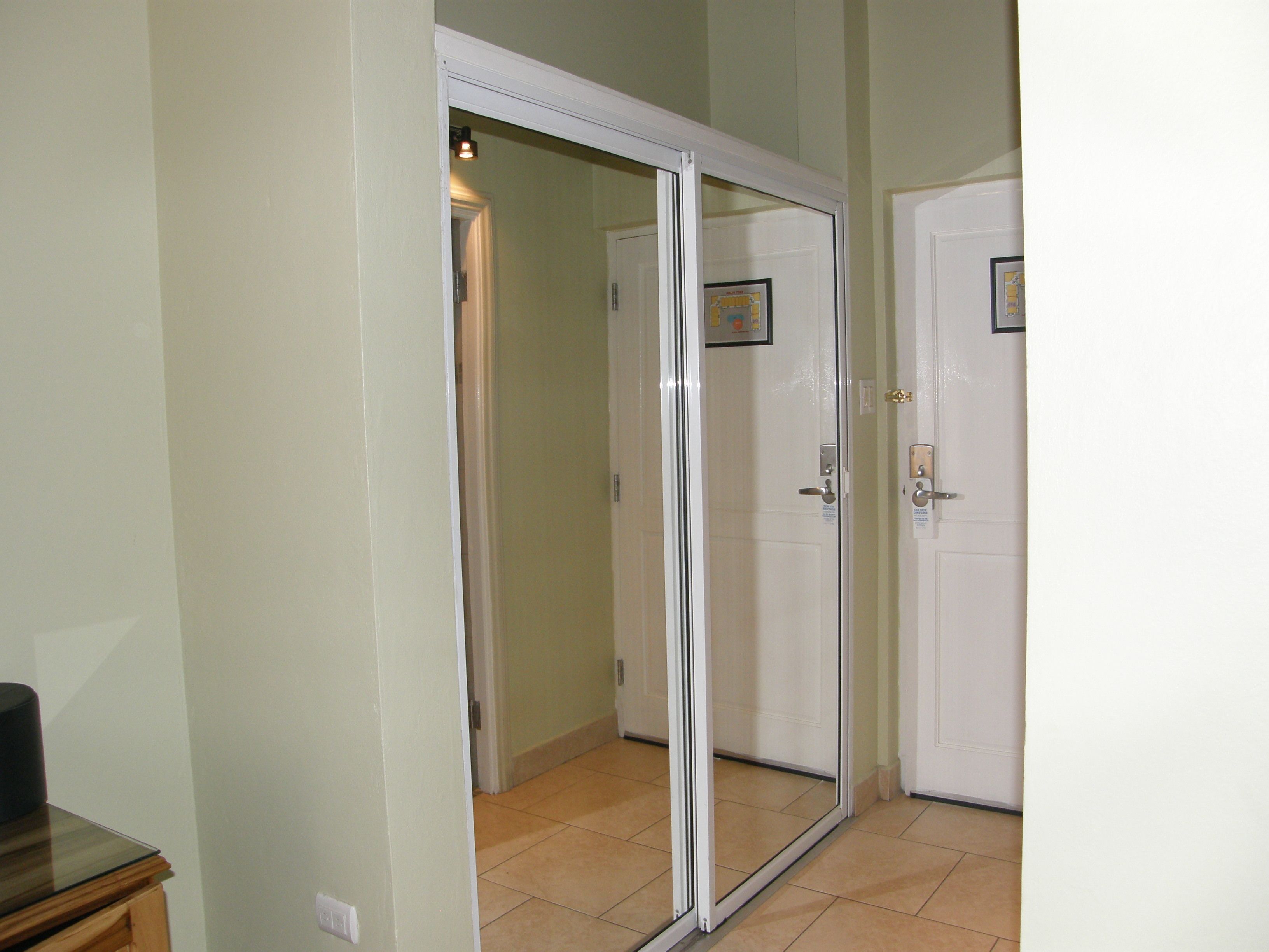 A hallway with a sliding glass door leading to a room.