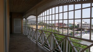 A covered balcony with a view of a parking lot and buildings. - Hotel Four Seasons (Kingston)