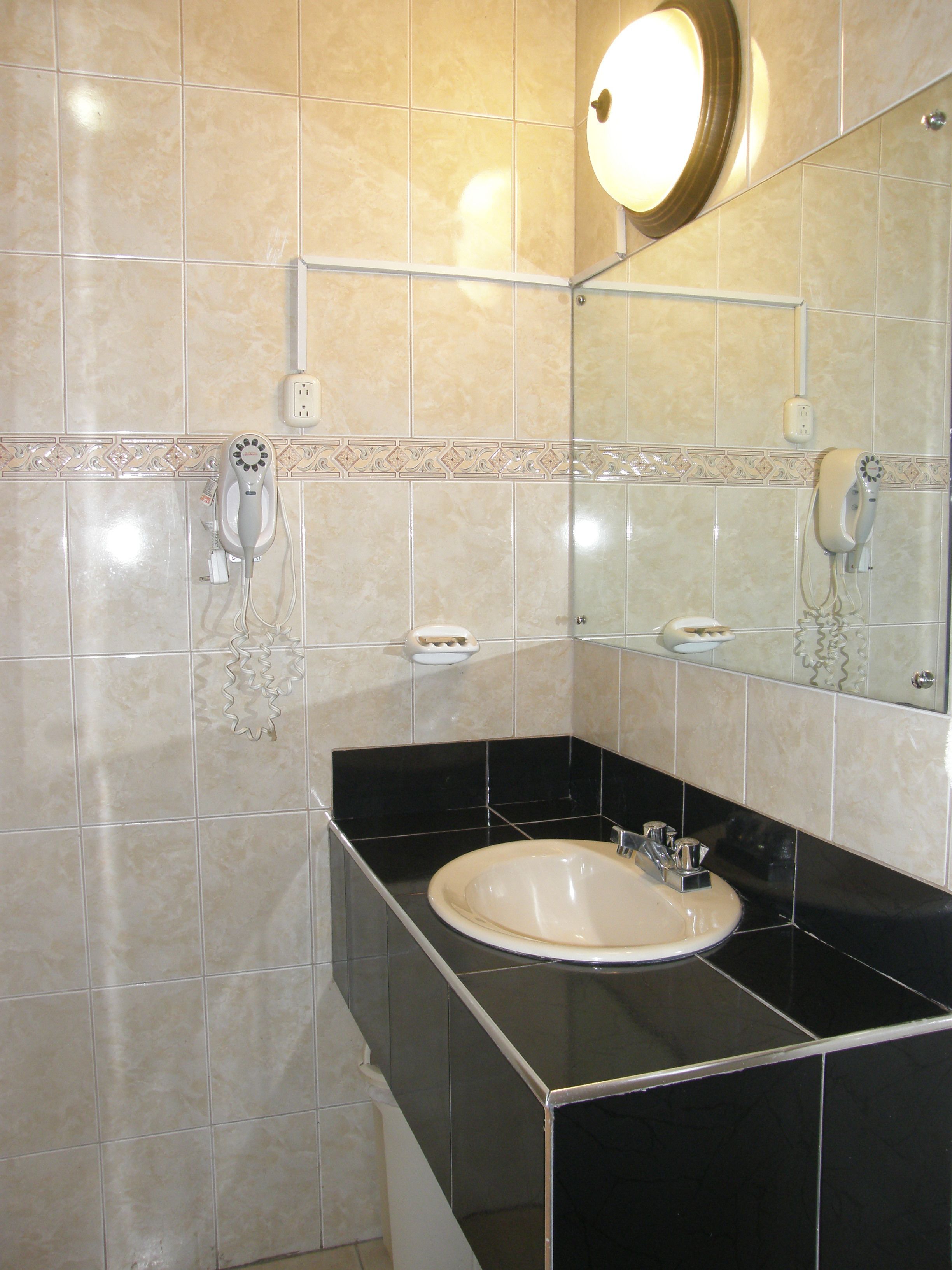 A bathroom with a sink, mirror, and towel rack.