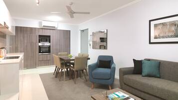 A modern living room with a sofa, armchair, coffee table, and a dining area with chairs and a table.