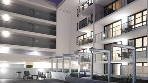 A modern hotel with a swimming pool, multiple balconies, and outdoor seating areas. - Oaks Mackay Carlyle Suites (Mackay)